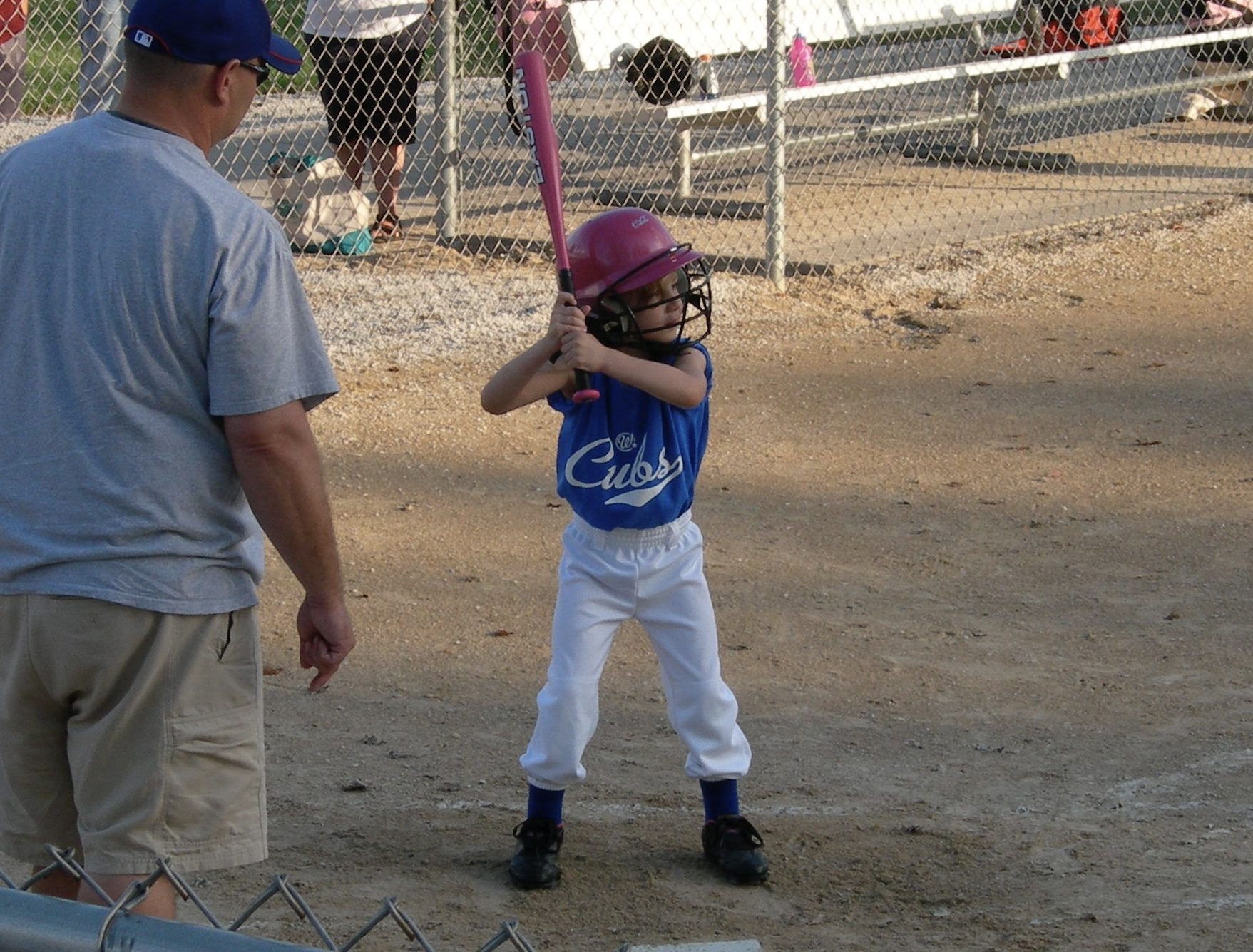Young Teagan at bat in a pink helmet