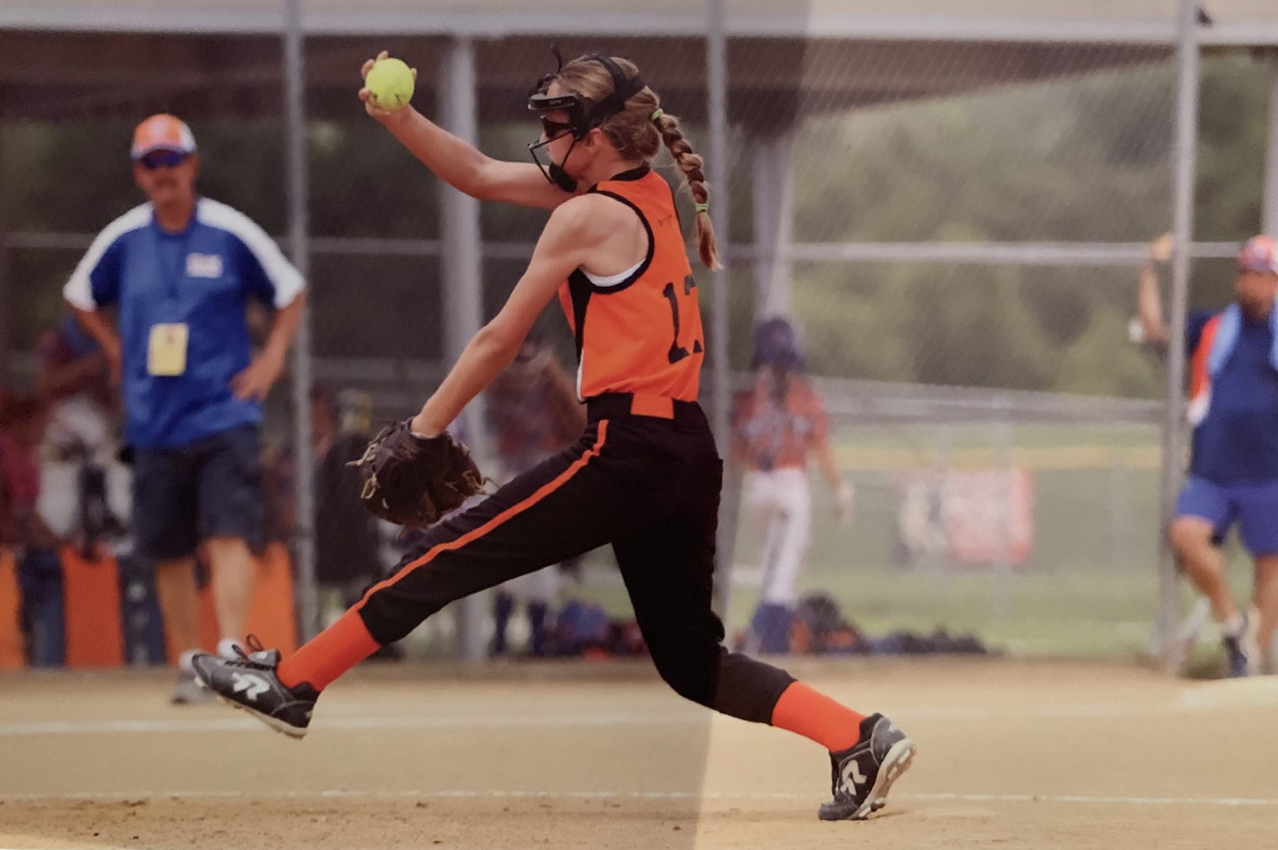 Young Teagan pitching in an orange #17 jersey